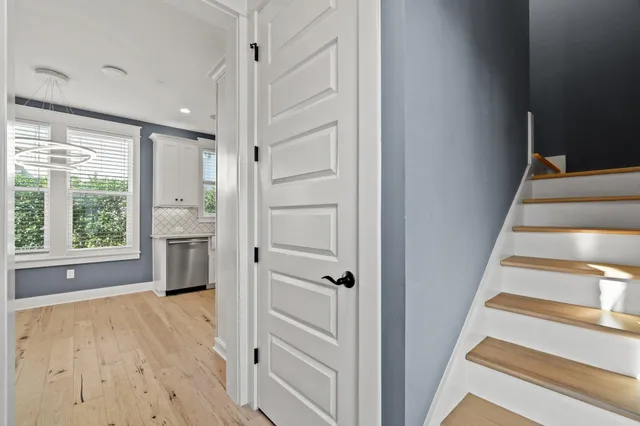 a view of a hallway with wooden floor and staircase