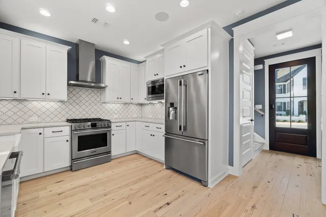 a kitchen with a refrigerator stove and wooden cabinets