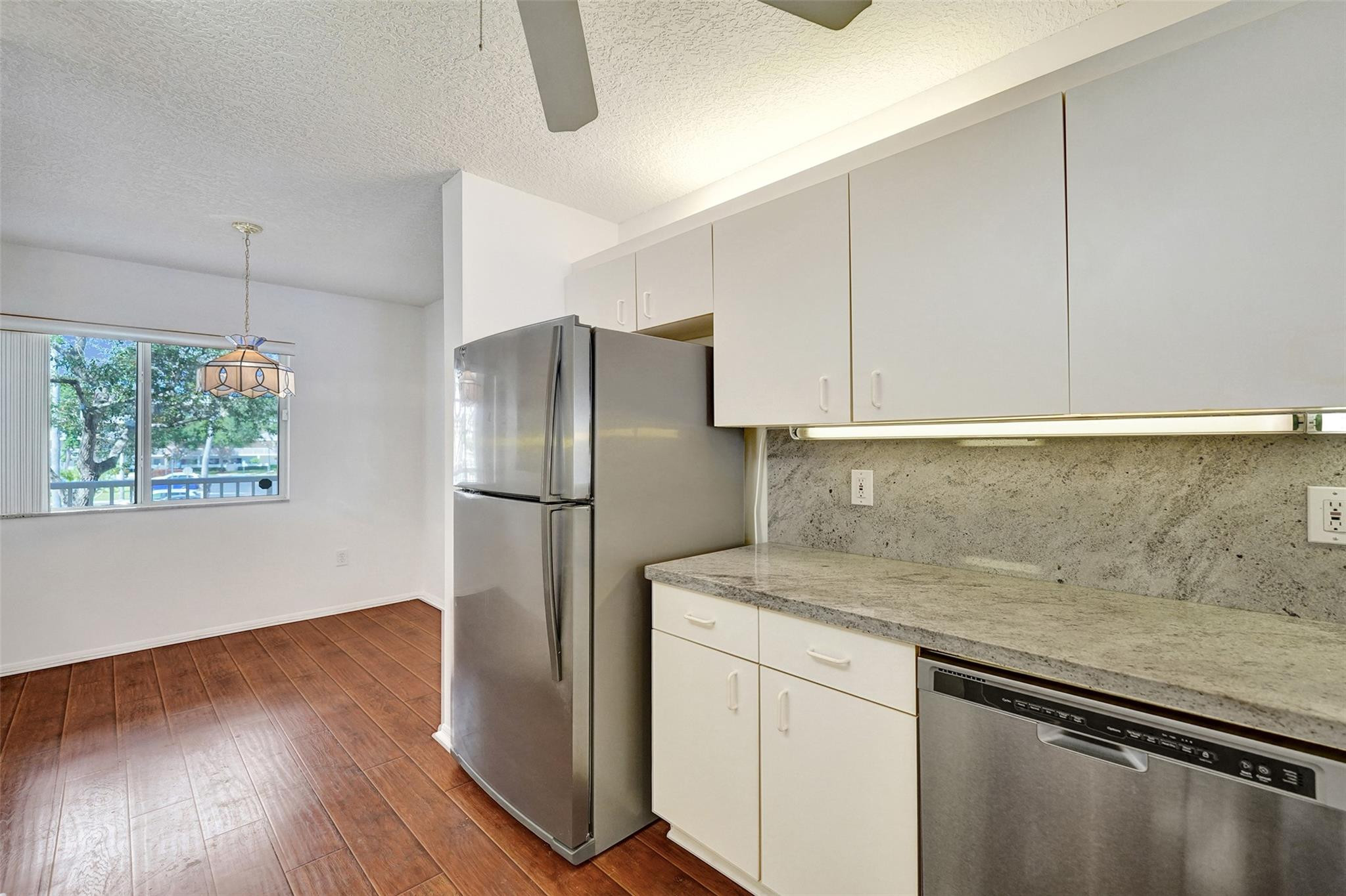 9563 Weldon Circle, Unit D212 Tamarac, FL 33321 - Photo 14 of 69 a kitchen with stainless steel appliances granite countertop a refrigerator and a sink