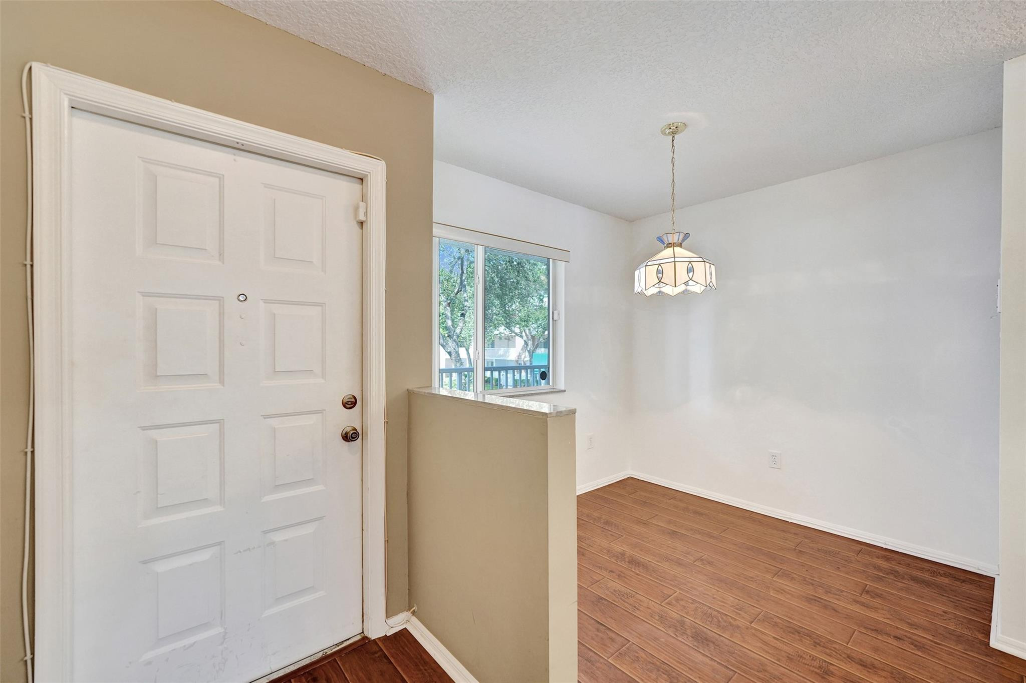 9563 Weldon Circle, Unit D212 Tamarac, FL 33321 - Photo 4 of 69 an empty room with wooden floor cabinet and windows