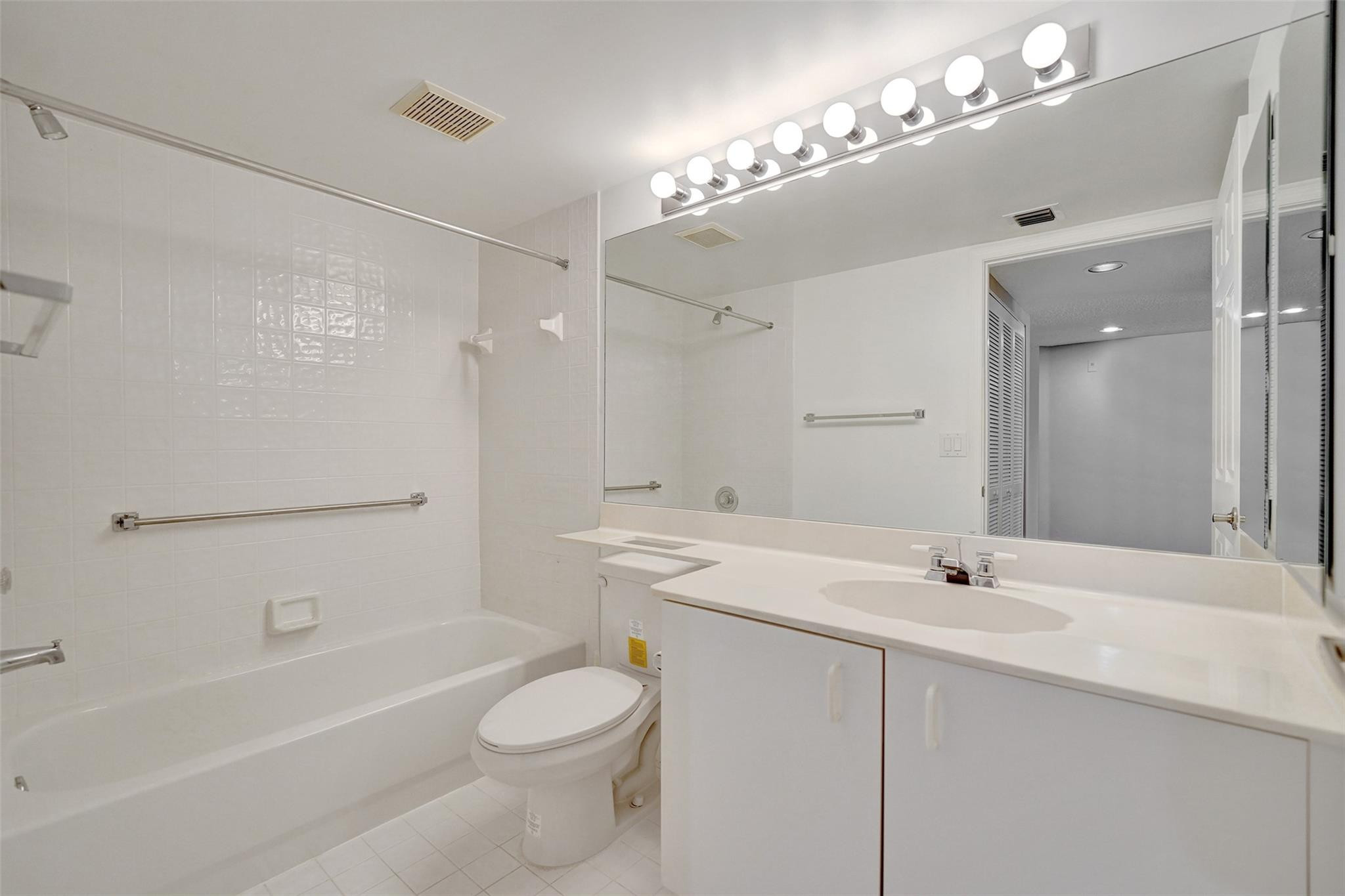 9563 Weldon Circle, Unit D212 Tamarac, FL 33321 - Photo 45 of 69 a bathroom with a sink a toilet a mirror and shower