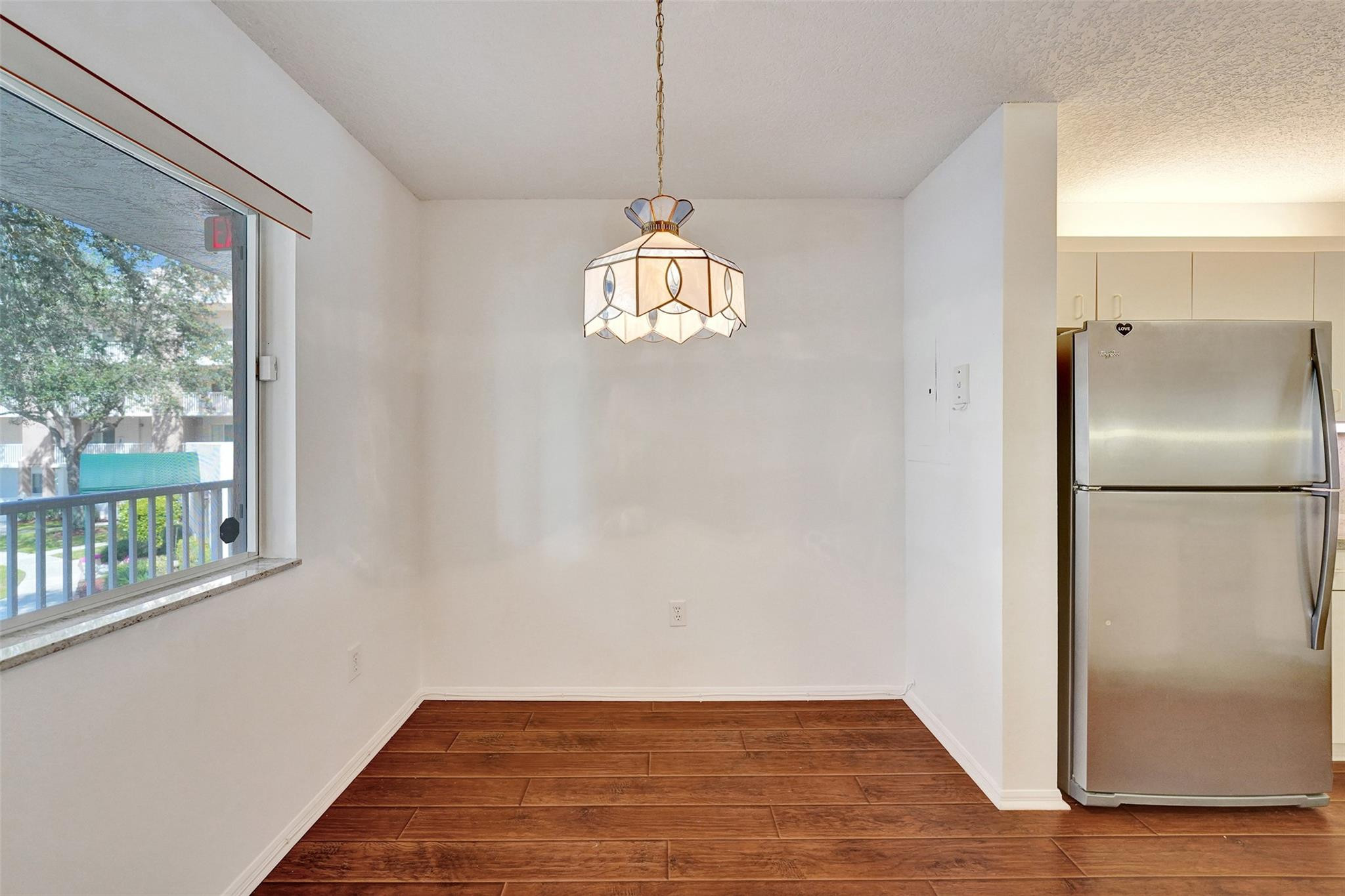 9563 Weldon Circle, Unit D212 Tamarac, FL 33321 - Photo 5 of 69 a view of a room with wooden floor a ceiling fan and windows