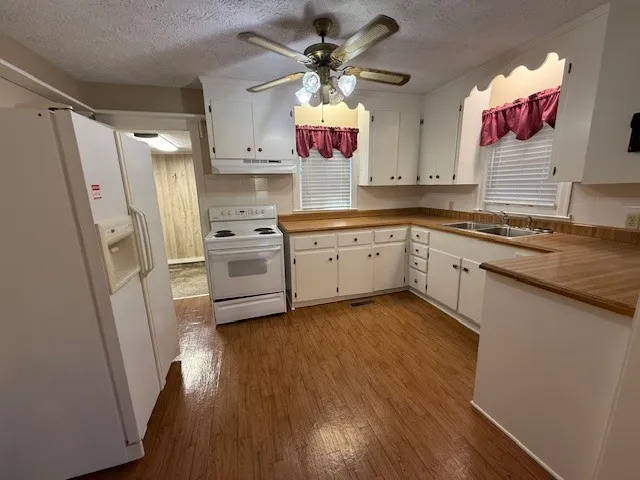 a kitchen with a sink wooden floor and stainless steel appliances
