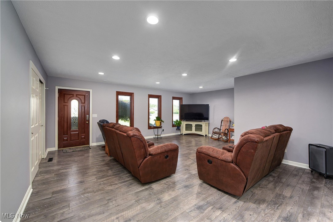 Living room with dark hardwood / wood-style flooring and a textured ceiling