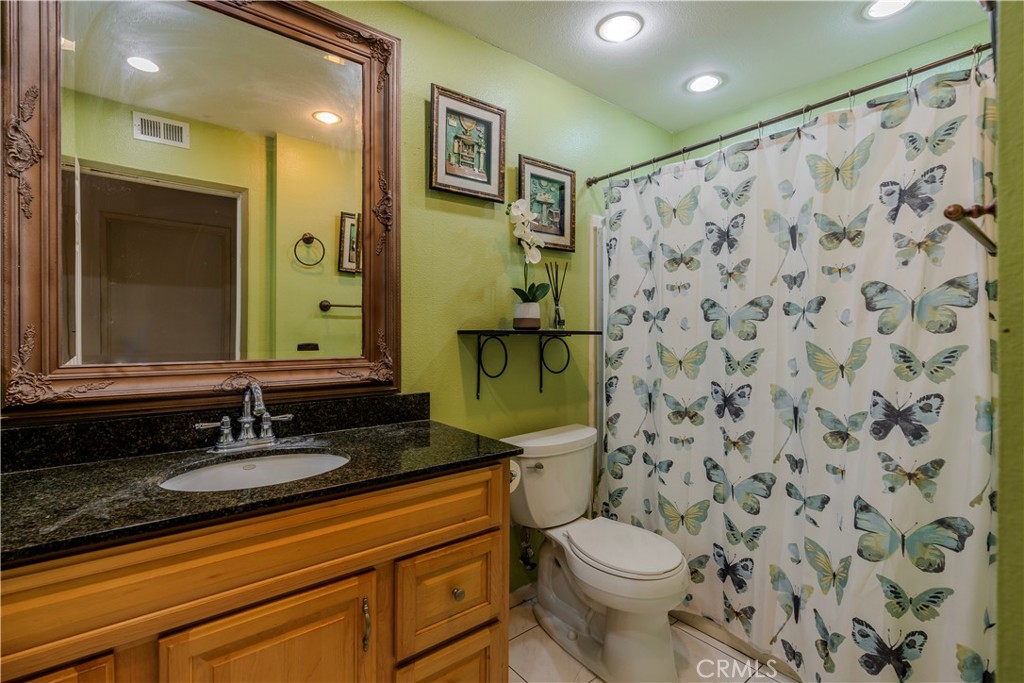 3366 Darby Street, Unit 435 Simi Valley, CA 93063 - Photo 10 of 19 a bathroom with a granite countertop sink a toilet and a mirror