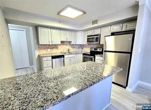 a kitchen with stainless steel appliances granite countertop a refrigerator sink and stove