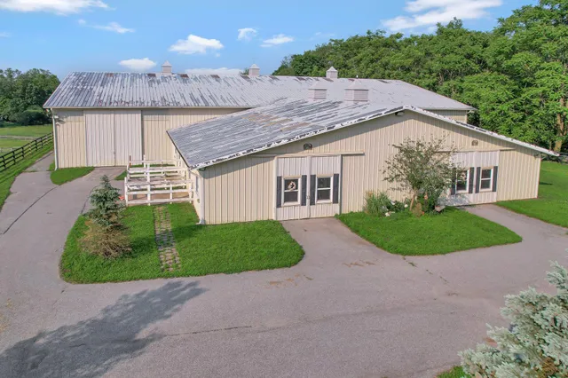 a view of a house with a yard and large tree