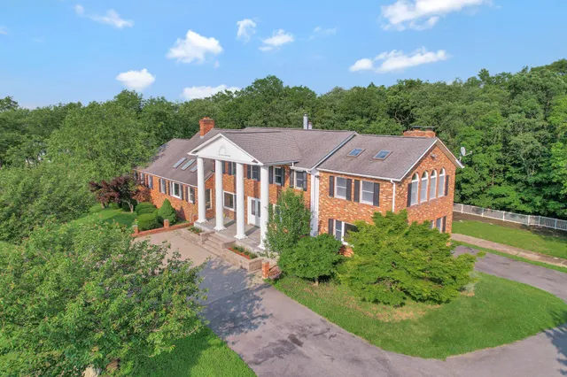 a aerial view of a house with yard and green space