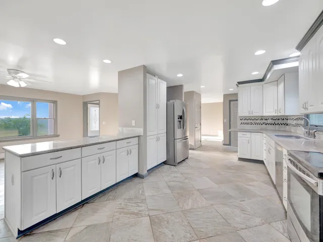 a kitchen with granite countertop white cabinets and white appliances