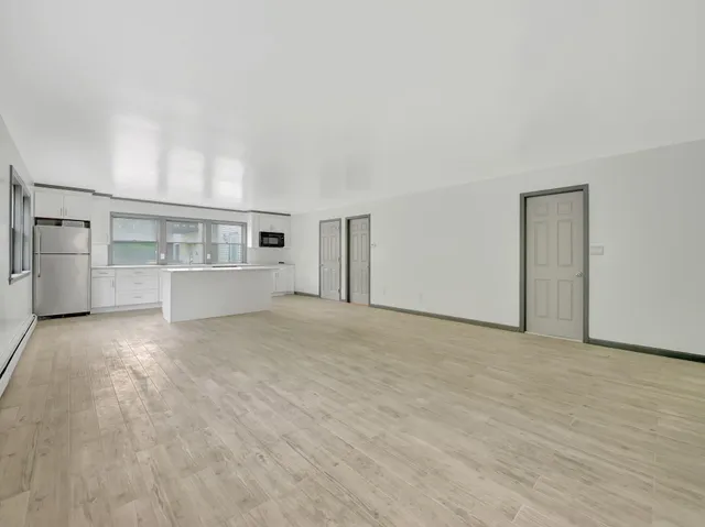 a kitchen with granite countertop a stove a sink a window and a wooden floor