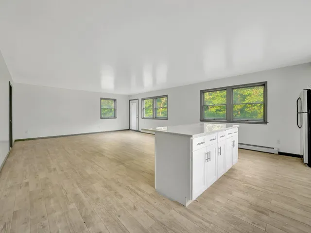 a kitchen with granite countertop white cabinets and black stainless steel appliances