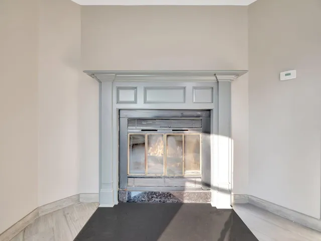 a view of an empty room with window and fire place