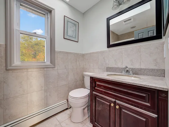 a bathroom with a toilet a sink and mirror