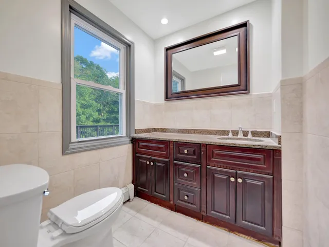 an empty room with wooden floor fireplace and windows