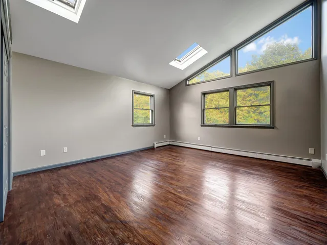 an empty room with window and wooden floor