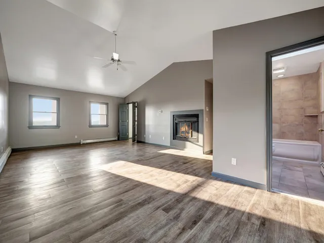 a view of a livingroom with wooden floor and a ceiling fan