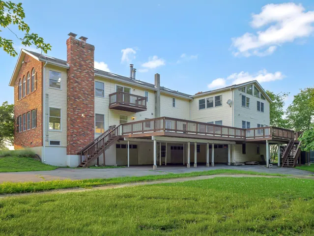 a view of a big house with a big yard and large trees