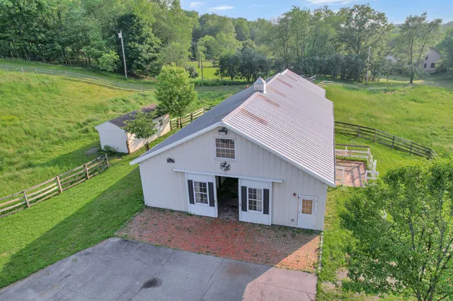 a aerial view of a house next to a big yard with large trees