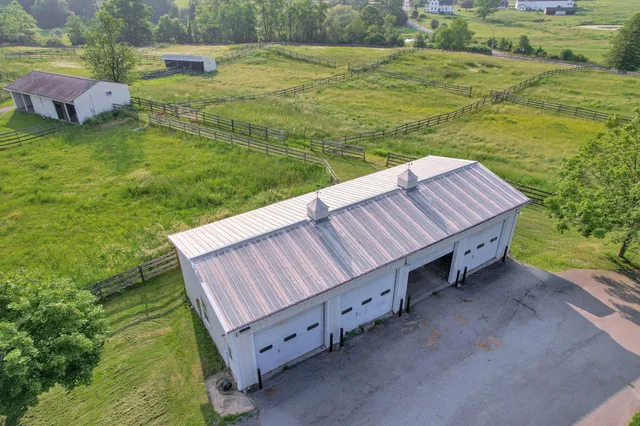 a view of a backyard with lawn chairs under an umbrella