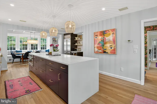 a kitchen with stainless steel appliances a large counter top a stove and a chandelier