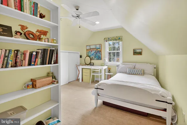 a bedroom with a bed and a lamp on a dresser