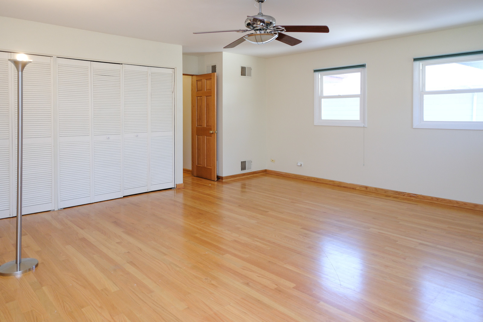 S586 East Street Winfield, IL 60190 - Photo 21 of 29 an empty room with wooden floor chandelier fan and windows