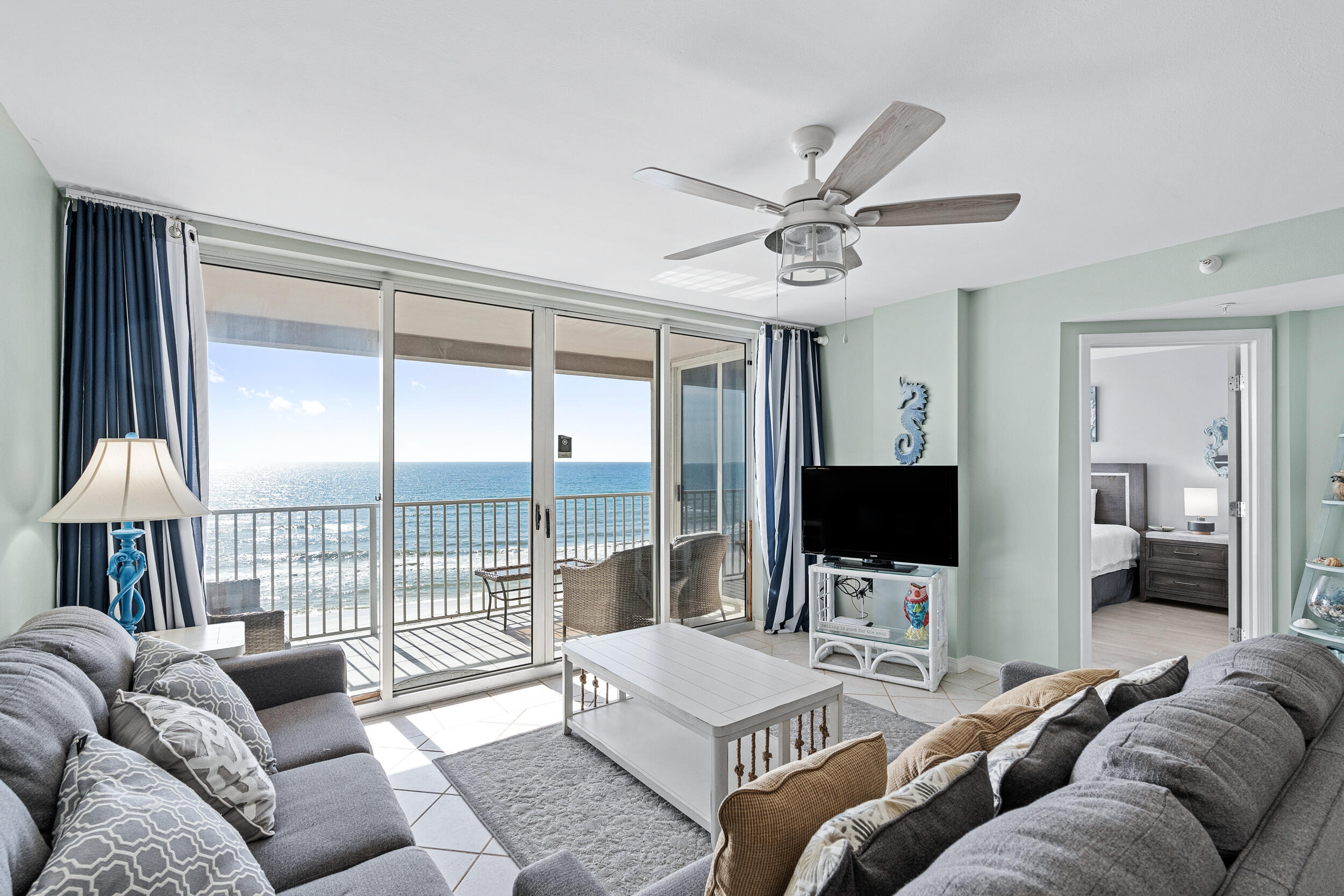 a living room with furniture a flat screen tv and a large window