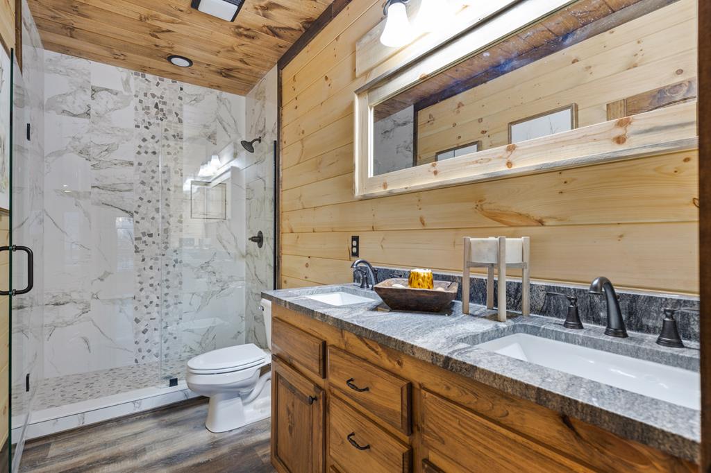 108 Shalom Lane Blue Ridge, GA 30513 - Photo 51 of 62 a bathroom with a granite countertop sink a toilet and shower
