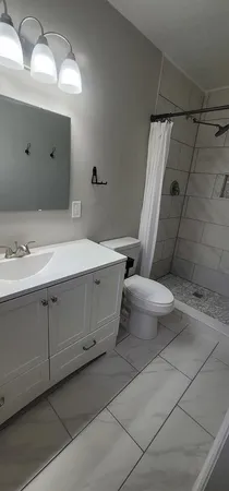 a bathroom with a double vanity sink toilet and shower