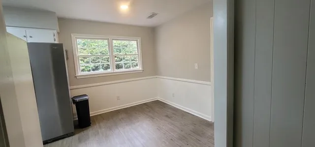 an empty room with wooden floor and a window