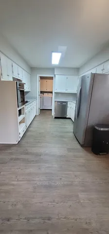 a view of a kitchen with a sink and a refrigerator
