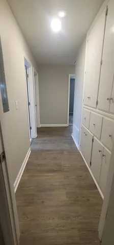 an empty room with wooden floor and cabinet