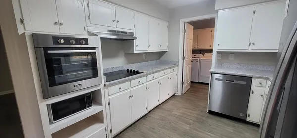 a kitchen with stainless steel appliances white cabinets and a stove