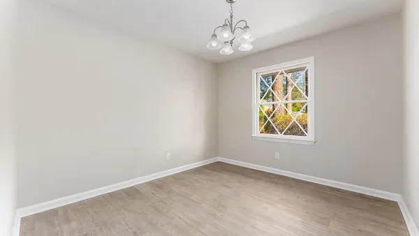 an empty room with windows and chandelier