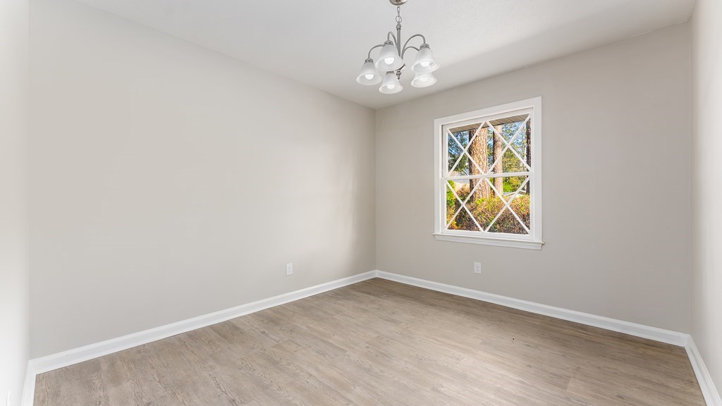 3327 College Avenue Columbus, GA 31907 - Photo 6 of 29 an empty room with windows and chandelier