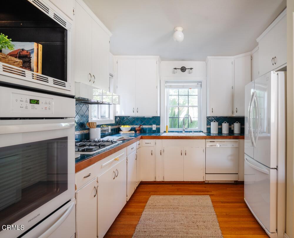 2484 Page Drive Altadena, CA 91001 - Photo 7 of 27 a kitchen with white cabinets and white appliances