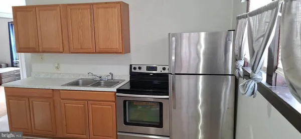 a kitchen with appliances a refrigerator and cabinets