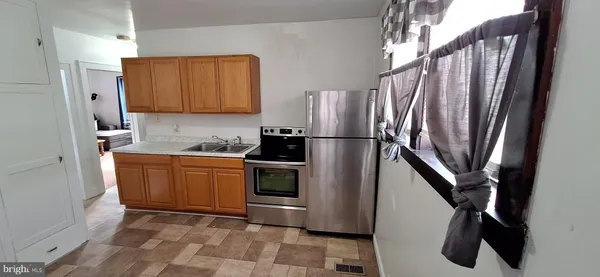 a kitchen with stainless steel appliances granite countertop a refrigerator a stove and a sink