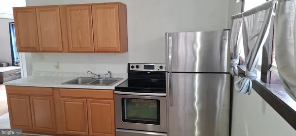 a kitchen with appliances a refrigerator and cabinets