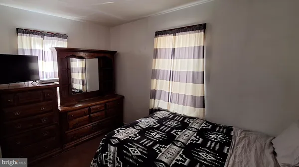 a bedroom with a bed and flat tv screen