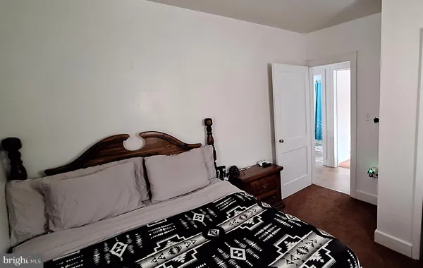 a bedroom with bed and wooden floor