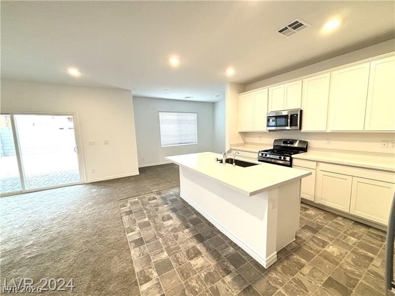 8336 Rowan Rdg Avenue Las Vegas, NV 89147 - Photo 4 of 15 This inviting space combines kitchen and living areas, offering a bright and functional environment.