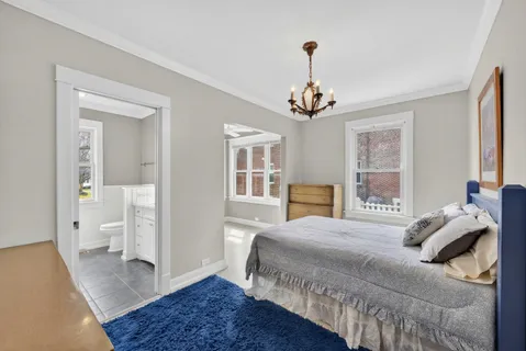 a bedroom with a large bed and a chandelier
