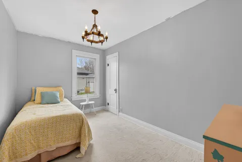 a bedroom with a bed and a chandelier
