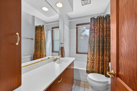 a bathroom with a sink a toilet a mirror and shower