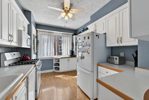 a kitchen with stainless steel appliances a stove a refrigerator a sink dishwasher and cabinets with wooden floor