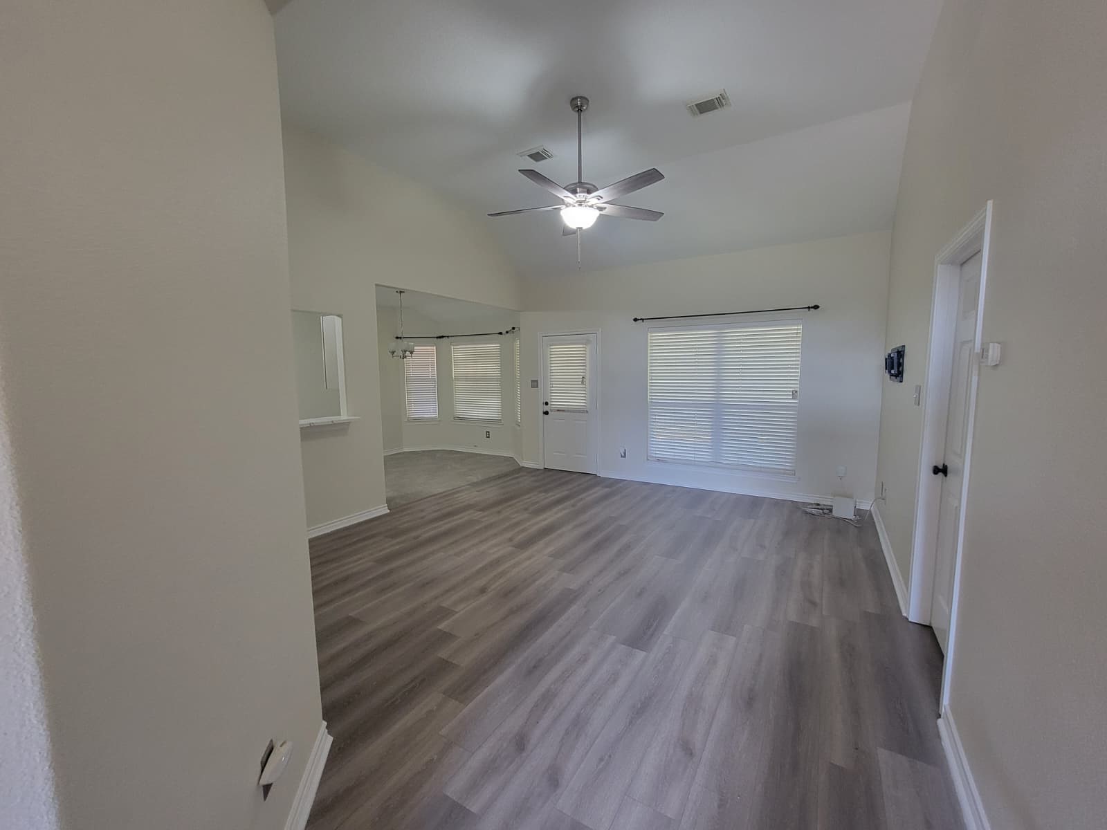 320 Old San Felipe Road Sealy, TX 77474 - Photo 10 of 12 Spacious living area with vaulted ceilings, modern laminate flooring, and abundant natural light from large windows.