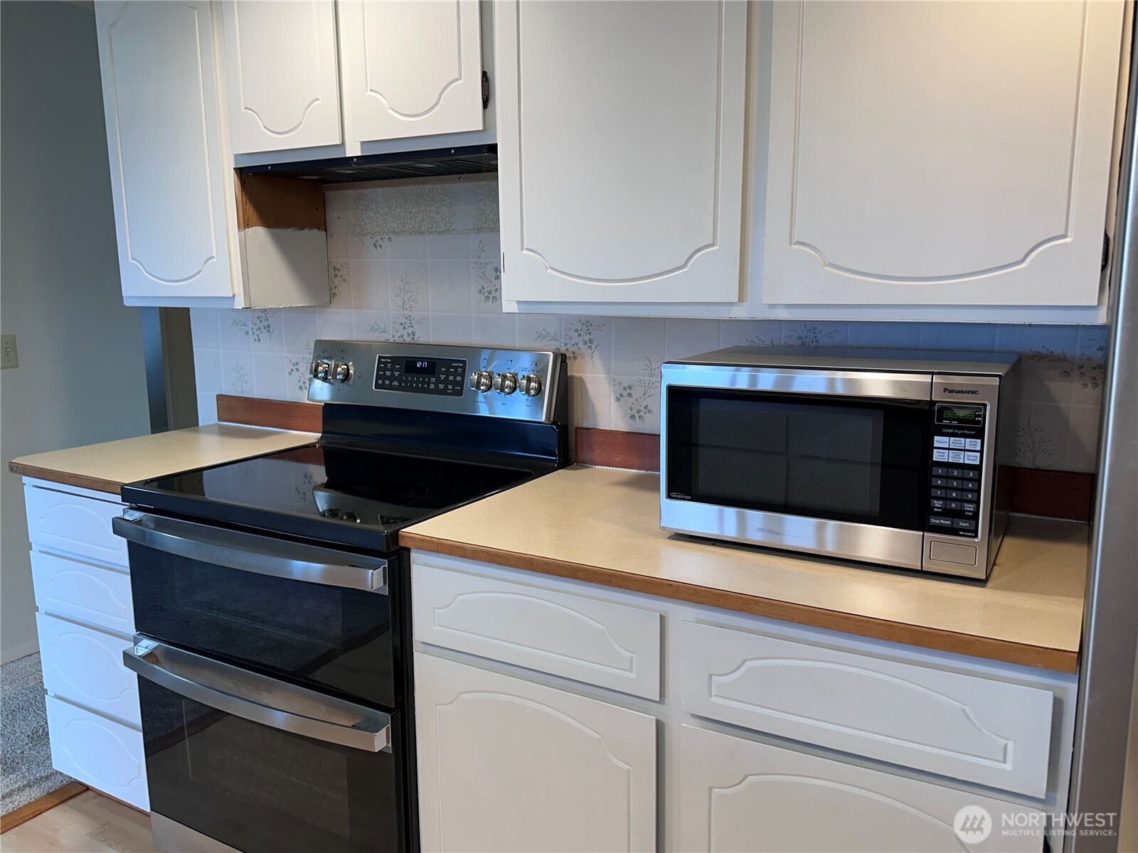 1301 South 3rd Avenue, Unit 7D Sequim, WA 98382 - Photo 15 of 32 a kitchen with granite countertop white cabinets appliances and a sink
