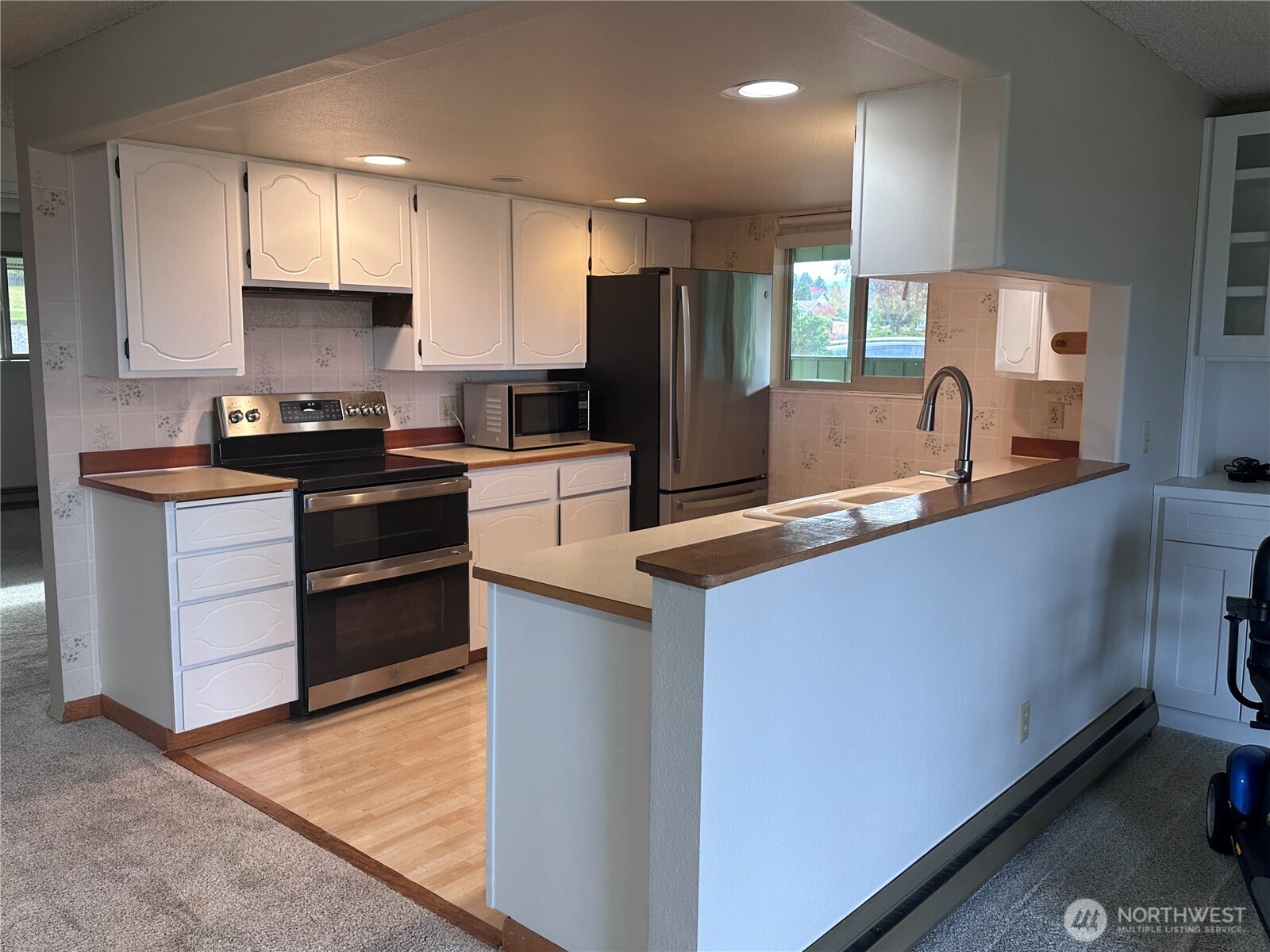 1301 South 3rd Avenue, Unit 7D Sequim, WA 98382 - Photo 16 of 32 a kitchen with stainless steel appliances granite countertop a sink stove and refrigerator