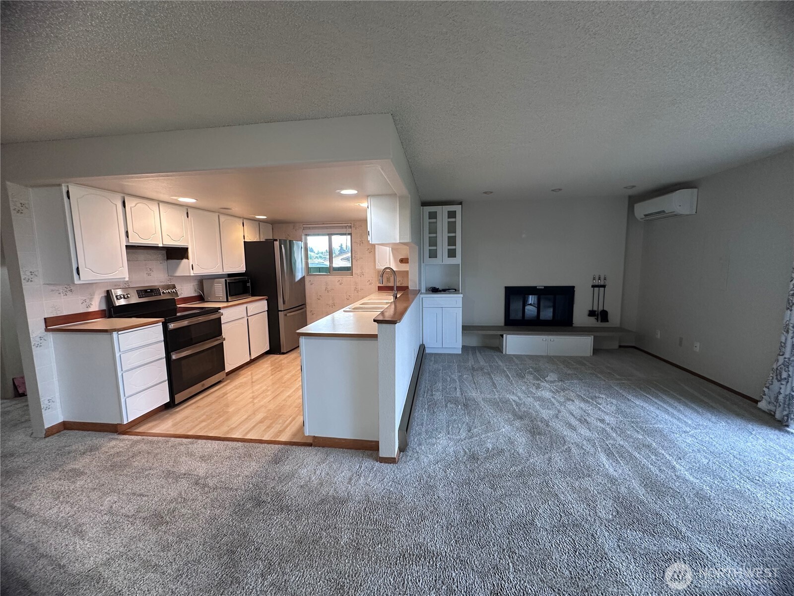 1301 South 3rd Avenue, Unit 7D Sequim, WA 98382 - Photo 23 of 32 a kitchen with stainless steel appliances a stove top oven a sink a window and white cabinets